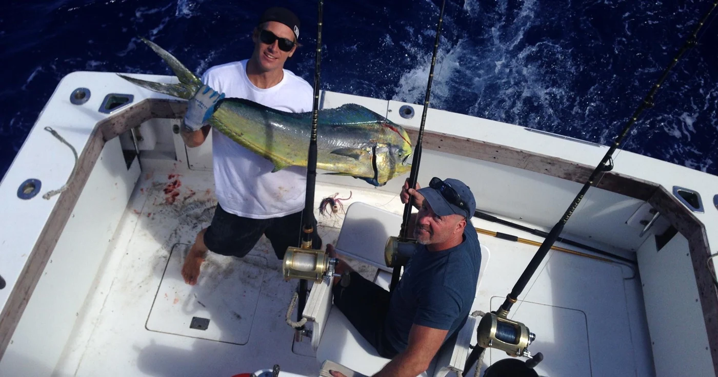 Angler holding a mahi mahi on a Go Fish Kauai charter